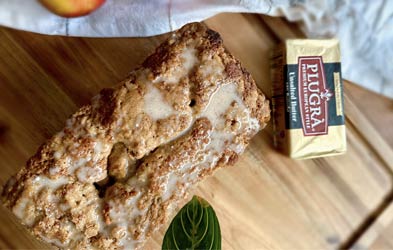 Apple Crumble Loaf on a table next to unsalted butter and two apples