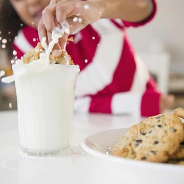 girl dunking cookie in milk