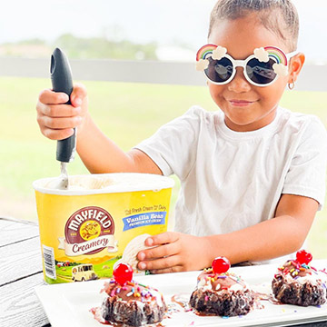 Young girl scooping ice cream wearing rainbow glasses