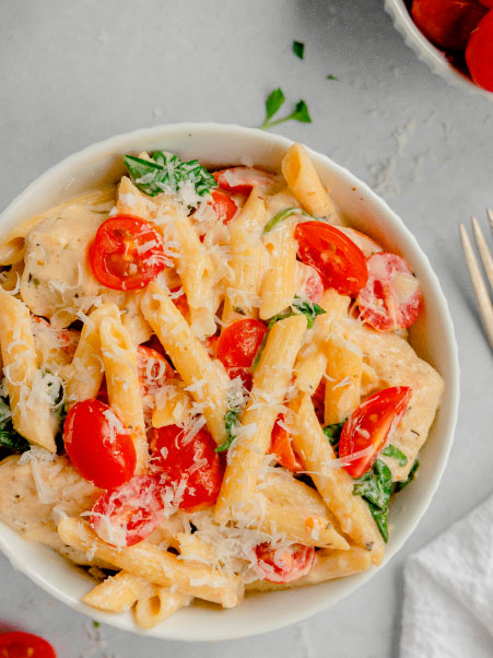End your day with a quick pasta in a light cottage cheese sauce topped with fresh cherry tomatoes, basil, and Parmesan cheese. 