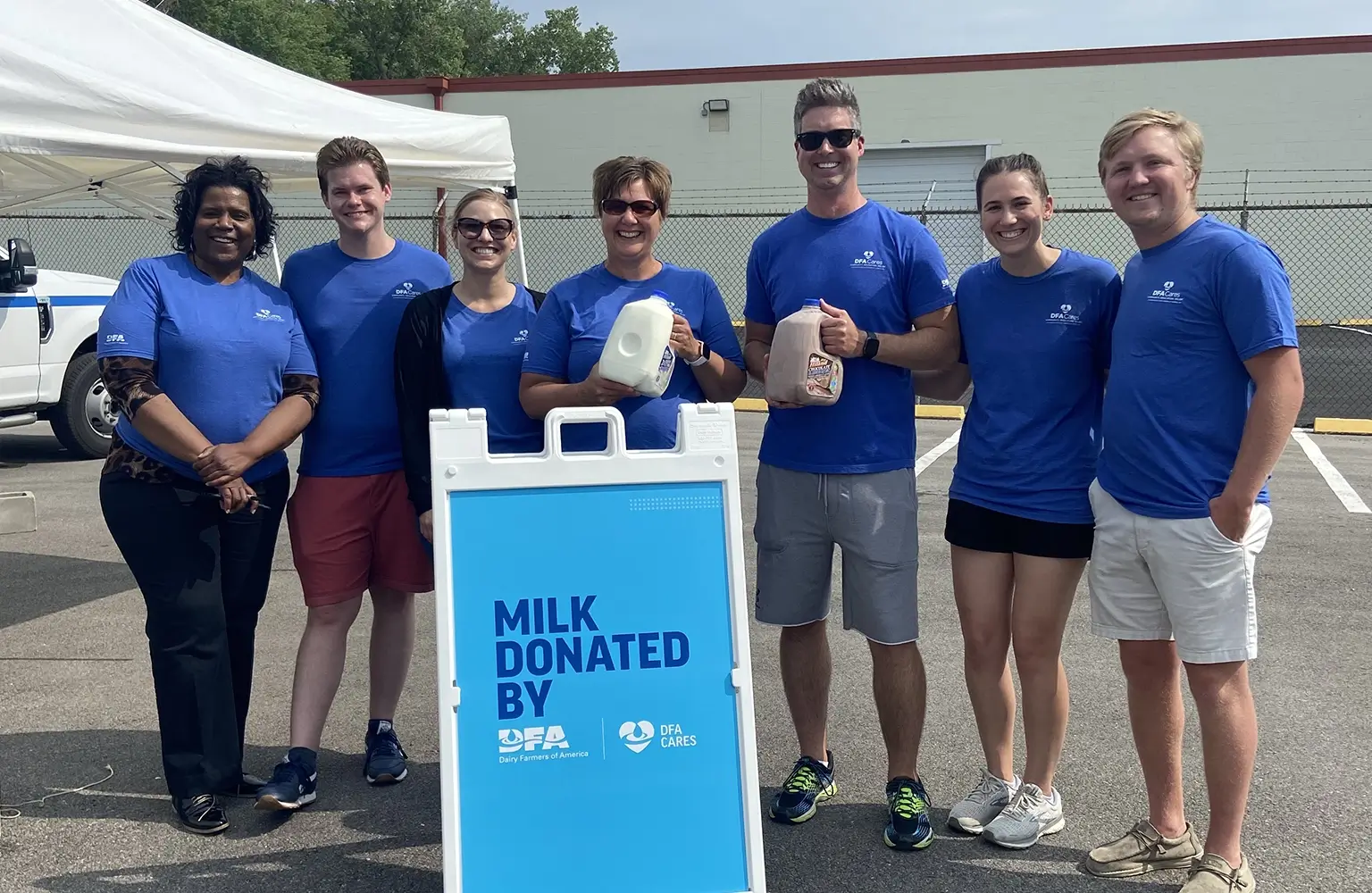 A team of DFA volunteers pose for a photo with a sign that reads "Milk Donated by DFA and DFA Cares Foundation.