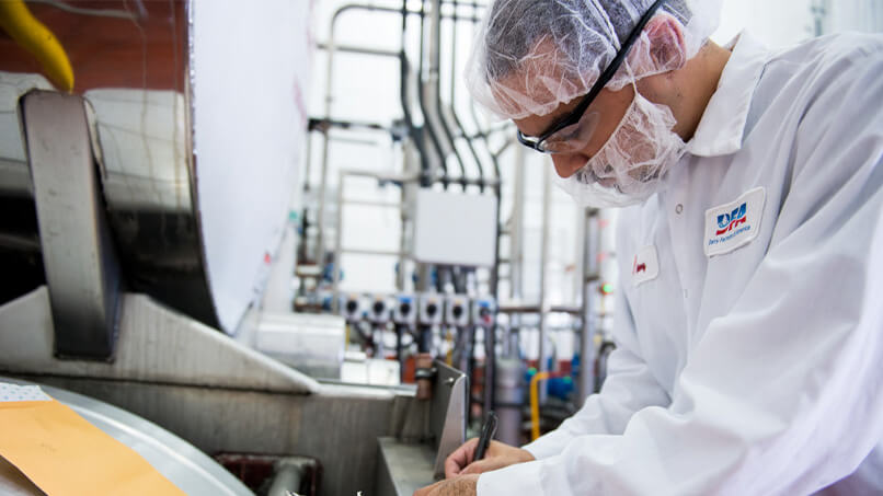 A DFA dairy manufacturing plant operator taking notes.